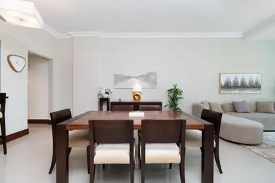a dining room with a table and chairs and a couch at Walnut Palm 2BR - Palm Jumeirah in Dubai