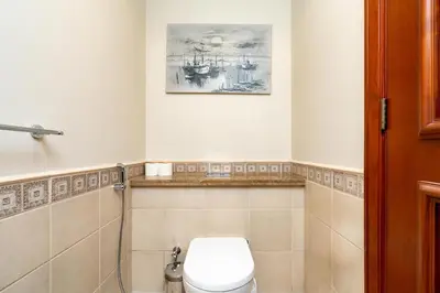 a bathroom with a toilet and a picture on the wall at Walnut Palm 2BR - Palm Jumeirah in Dubai