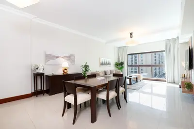 a living room with a dining room table and chairs at Walnut Palm 2BR - Palm Jumeirah in Dubai