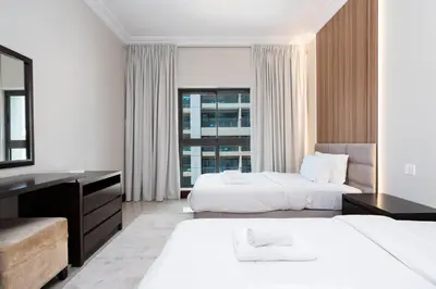 a hotel room with two beds and a window at Walnut Palm 2BR - Palm Jumeirah in Dubai