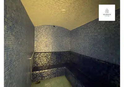 a bathroom with a tiled wall with a handicapped at KeyRock Living - Modern 1BR at Zada Tower with Pool and Gym Facilities in Dubai