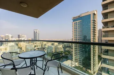 a balcony with a table and chairs and a view of a city at Stylish 1BR Retreat with Pool and Stunning City View in Dubai