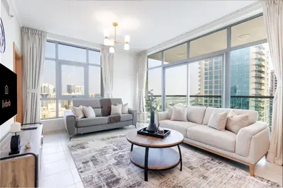a living room with a couch and a table at Stylish 1BR Retreat with Pool and Stunning City View in Dubai