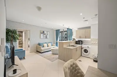 a kitchen and a living room with a couch at Seven Palm Elite 1BR-Infinity Pool & Skyline Views in Dubai