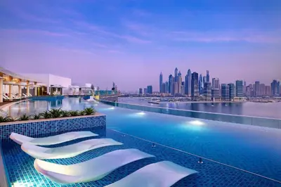 a hotel swimming pool with a view of a city at Seven Palm Elite 1BR-Infinity Pool & Skyline Views in Dubai