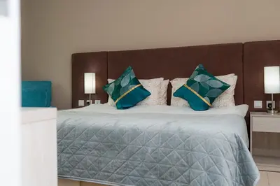 a bedroom with a bed with blue and green pillows at Stylish 1-BR Beachfront Apt on SEVEN PALM Dubai in Dubai