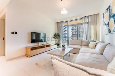 a living room with a couch and a tv at Steps Away From JBR Beach And Marina Promenade, Quick Access To Palm Jumeirah, Surrounded by Leisure And Entertainment Hubs - Marina Vista Tower 2, Emaar Beachfront by Deluxe Holiday Homes in Dubai