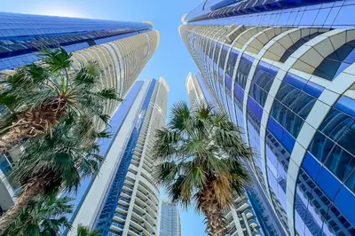 two tall buildings with palm trees in front of them at Luxury Living at Paramount Tower B, Business Bay in Dubai