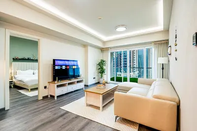 a living room with a couch and a tv at Escape24 Luxury 2BR with Large Balcony and Lake Views in Dubai