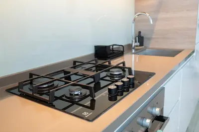 a black stove top in a kitchen next to a sink at Chic 2BHK Retreat with Marina Views by Czechin in Dubai