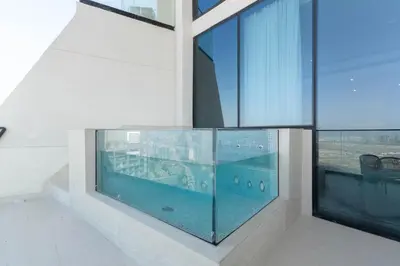 a swimming pool in the middle of a building with windows at The Royale Blue Suite 610 I JVC I Plunge Pool Parking Gym in Dubai