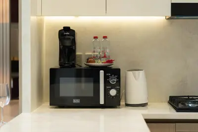 a microwave sitting on top of a kitchen counter at The Royale Blue Suite 610 I JVC I Plunge Pool Parking Gym in Dubai