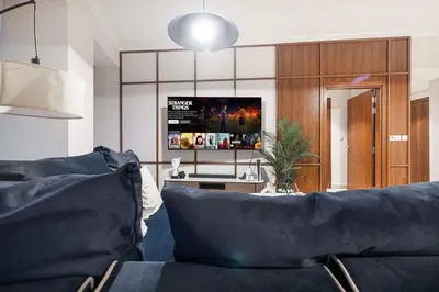 a living room with a couch and a flat screen tv at Modern 4BR Suite Overlooking Downtown in Dubai