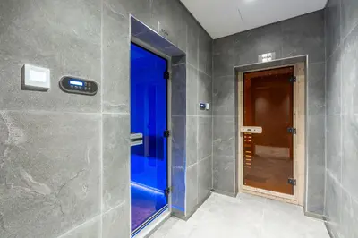a bathroom with gray walls and a glass door at Samaya Holiday Homes - Cloud Stylish Suites with Balcony in Dubai
