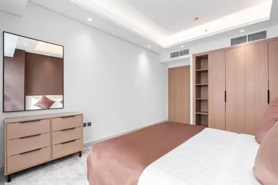 a bedroom with a large bed and a mirror at Samaya Holiday Homes - Cloud Stylish Suites with Balcony in Dubai