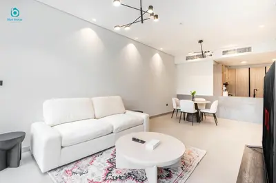 a living room with a white couch and a table at Blue Breeze Cozy 1 BR in JVC Al Serh Residence 11 in Dubai