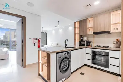 a kitchen with a washer and dryer in it at Blue Breeze Cozy 1 BR in JVC Al Serh Residence 11 in Dubai