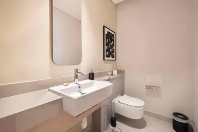 a white bathroom with a sink and a toilet at 2BR Luxury Hotel Amenities Dubai Mall Access in Dubai