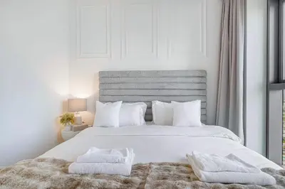 a white bedroom with a large bed with white pillows at 4Bedroom Luxury Stay in Downtown Views Dubai Mall in Dubai