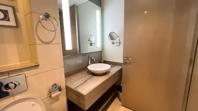 a bathroom with a sink and a toilet and a mirror at Burj Khalifa View High Floor and Brand New in Dubai