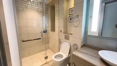 a bathroom with a toilet and a shower and a sink at Burj Khalifa View High Floor and Brand New in Dubai