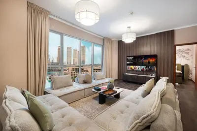 a living room with a large couch and a tv at Panoramic 4BR Burj Khalifa & Fountain View in Dubai