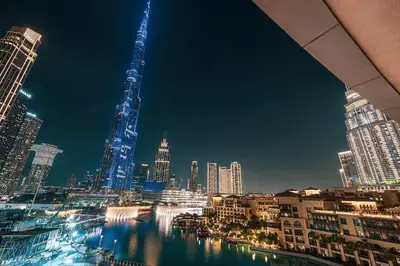 a view of a city skyline at night at Panoramic 4BR Burj Khalifa & Fountain View in Dubai
