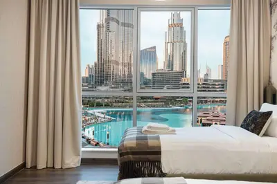 a bedroom with a large window with a view of the city at Panoramic 4BR Burj Khalifa & Fountain View in Dubai