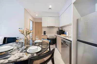 a kitchen and dining room with a table and chairs at Cozy 1Bedroom Apartment Downtown Dubai Retreat in Dubai