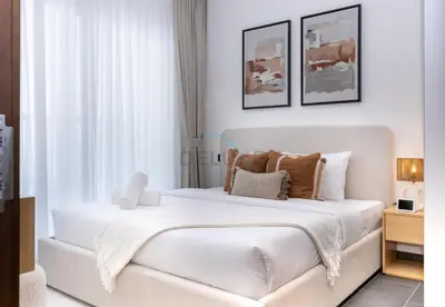 a white bedroom with a large white bed at Located Few Minutes Drive to Downtown Dubai, Burj Khalifa and Dubai Mall, Surrounded by Lush Green Community - Sobha Hartland The Crest Tower C by Deluxe Holiday Homes in Dubai