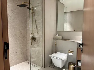 a bathroom with a shower and a toilet and a sink at Modern & Cozy 1BR Apartment with Full Comfort in Dubai