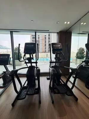 a gym with several treadmills in front of a window at Modern & Cozy 1BR Apartment with Full Comfort in Dubai