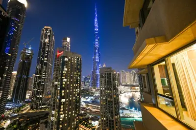 a view of a city skyline at night at 22nd Floor Burj Khalifa View 5 Min Walk Dubai Mall in Dubai