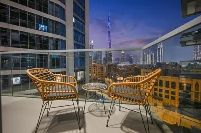 two chairs and a table on a balcony with a city skyline at Luxury 1BHK Burj Khalifa View Short Walk Dubai Mall in Dubai