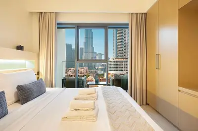 a hotel room with a bed and a large window at Designer 2BR, Burj Khalifa View & Dubai Mall 2 minutes walk in Dubai