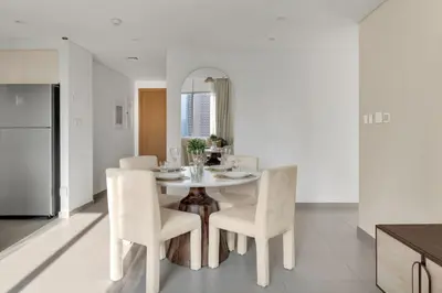 a kitchen and dining room with a white table and chairs at Stylish 2 bedroom with Burj Khalifa View, connected to Dubai Mall in Dubai