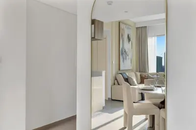 a living room with a dining room table and a mirror at Stylish 2 bedroom with Burj Khalifa View, connected to Dubai Mall in Dubai