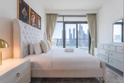 a bedroom with a white bed with a large window at Vacationer l Stunning 2 Bed l Marina Skyline l Beach Access in Dubai
