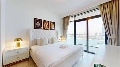 a bedroom with a white bed and a large window at Vacationer l Stunning 2 Bed l Marina Skyline l Beach Access in Dubai