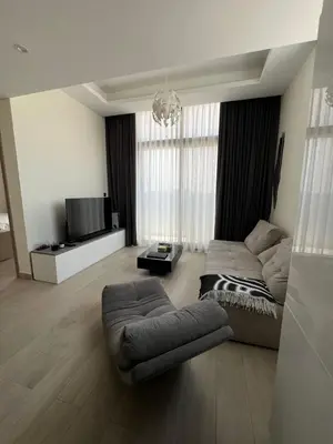a living room with a couch and a tv at Luxurious One Bedroom Apartment - Azizi Riviera in Dubai