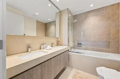 a bathroom with two sinks and a bath tub at Hermès 2BR Burj Khalifa & Fountain View With Direct Dubai Mall Access in Dubai