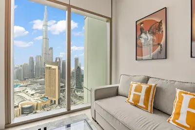a living room with a couch and a large window at Hermès 2BR Burj Khalifa & Fountain View With Direct Dubai Mall Access in Dubai