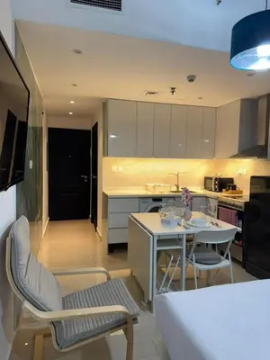 a kitchen and living room with a table and chairs at Cozy Studio in the Heart of Dubai Marina in Dubai