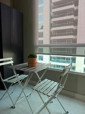 a table and a chair in front of a window at Cozy Studio in the Heart of Dubai Marina in Dubai