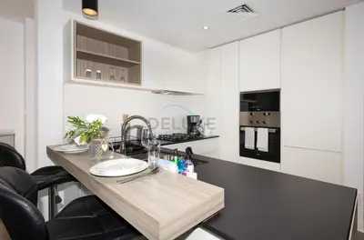 a kitchen with a wooden counter top with a sink at Central Location with Easy Access to Al Khail Road, Near Bus Stops, Supermarkets, Dining Spots, Minutes from Dubai Marina and Downtown - Belgravia Square B, JVC by Deluxe Holiday Homes in Dubai