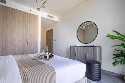 a bedroom with a large bed and a mirror at Frank Porter - Peninsula One in Dubai