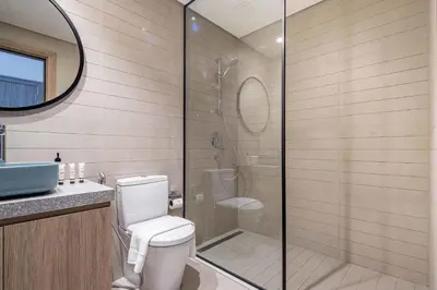 a bathroom with a toilet and a glass shower at Frank Porter - Peninsula One in Dubai