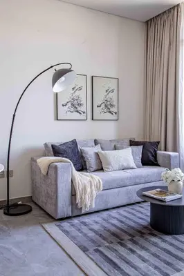 a living room with a couch and a floor lamp at Frank Porter - Peninsula One in Dubai