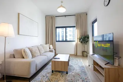 a living room with a couch and a flat screen tv at Silk Valley - Luxury 2B steps from Metro station in Dubai