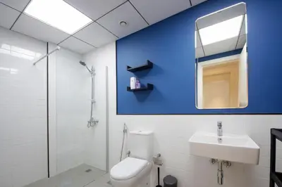 a bathroom with a toilet sink and a blue wall at Silk Valley - Luxury 2B steps from Metro station in Dubai